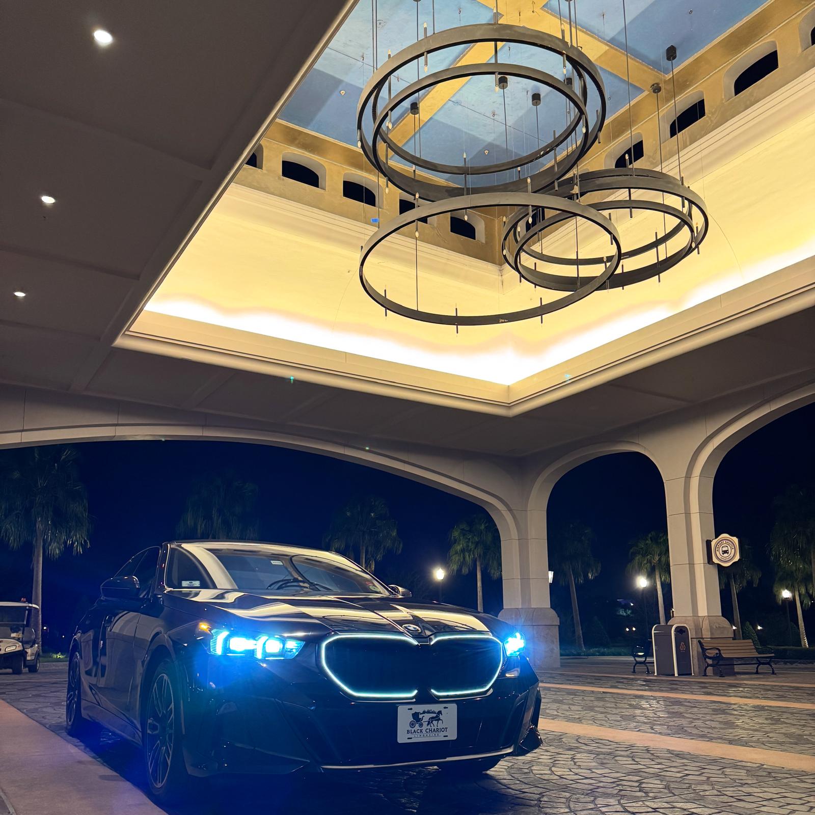 Black BMW luxury sedan at an upscale resort entrance near Windermere