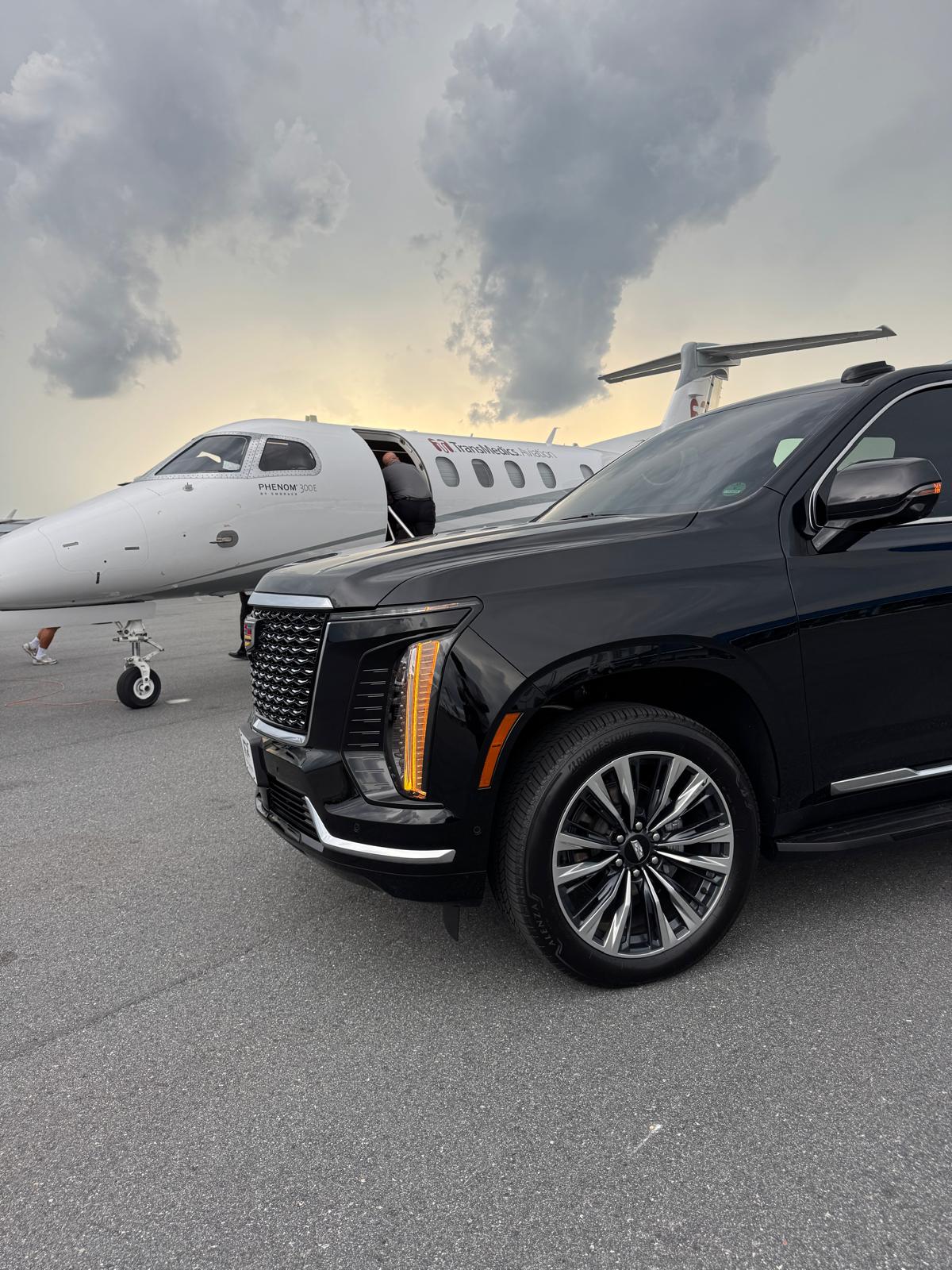 Black Cadillac Escalade beside a private jet for Port Canaveral cruise transfers