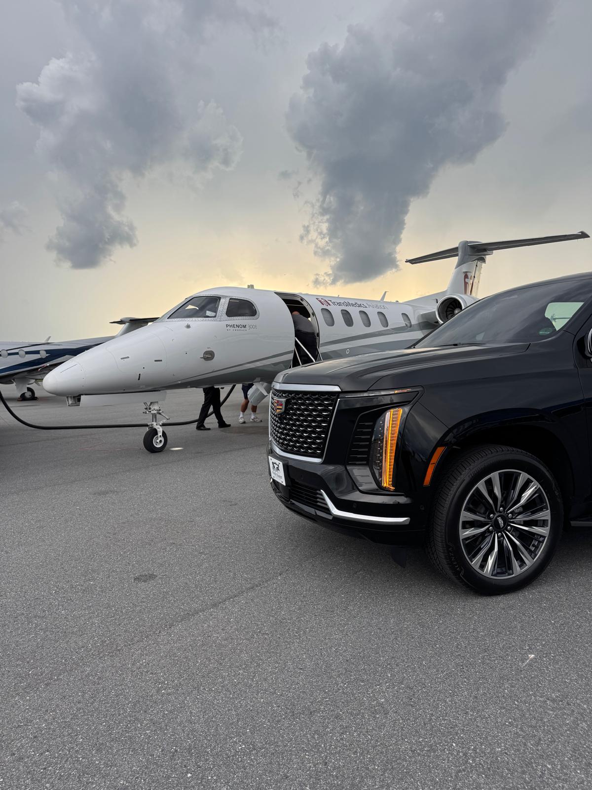 Black Cadillac Escalade beside a private jet for Florida cruise port transfers